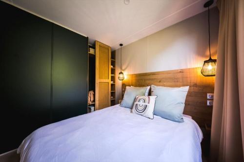 a bedroom with a bed with a sign on it at Mobil-home neuf - Au bleu du ciel in Plouhinec