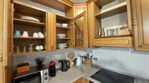 a kitchen with wooden cabinets and a counter top at Al Capitel in Grosotto