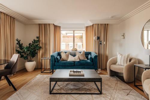 a living room with a blue couch and a table at The Eccleston by Nestor in London