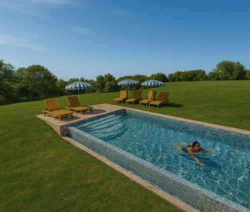 Casetta Valmora في Valpiana: امرأة مستلقية في حوض سباحة في حقل