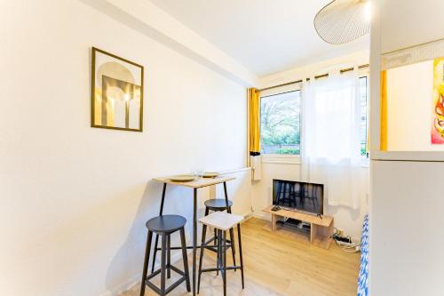 uma cozinha com dois bancos e uma mesa num quarto em Le charmant Jules Julien parking privé em Toulouse