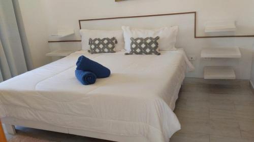 ein großes weißes Bett mit zwei blauen Kissen darauf in der Unterkunft Paradise Found 3Bedroom Apartment with Pool in Las Terrenas