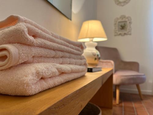 Casetta Valmora في Valpiana: كومة من المناشف موضوعة على طاولة مع مصباح