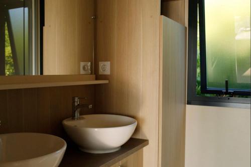 a bathroom with a white sink and a mirror at Chalet 35m2 - Armen in Plouhinec