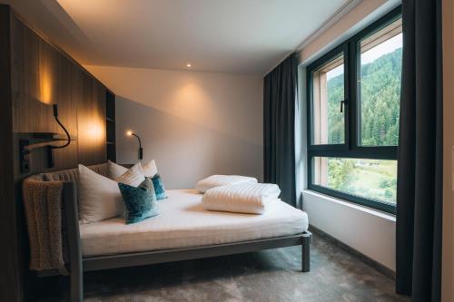 una cama en una habitación con ventana en Hotel Nassereinerhof, en Sankt Anton am Arlberg