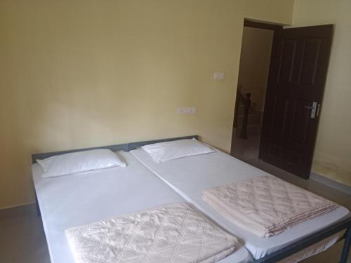 2 camas individuales en una habitación con puerta en Villa 9 degrees north, en Sultan Bathery