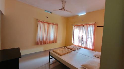 Habitación con cama, 2 ventanas y sofá. en Villa 9 degrees north, en Sultan Bathery