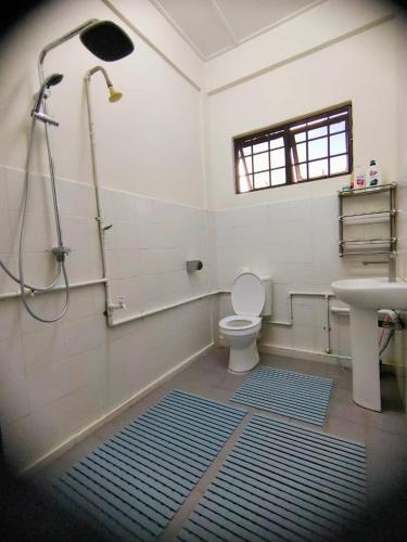 a bathroom with a shower and a toilet and a sink at HANNI HomeStay in Sibu