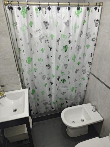 un baño con cortina de ducha con animales. en Centrico loft, en Puerto Madryn