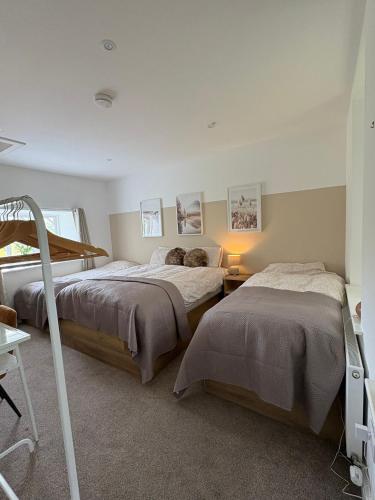 una camera con due letti e una scala interna di The School Cottage a Moyard