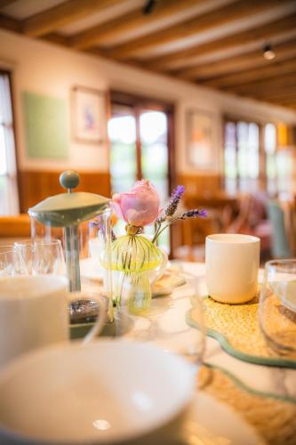 einen Tisch mit einer Blume in einer Vase darauf in der Unterkunft Casa Ecke-Frutillar bajo a una cuadra de la playa in Frutillar