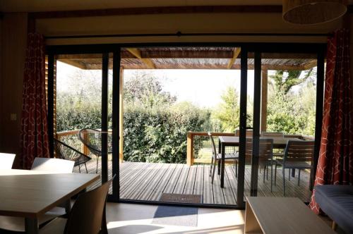 een woonkamer met een terras met een tafel en stoelen bij Chalet 35m2 - Molène in Plouhinec