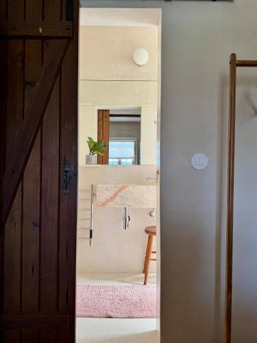 a door leading into a room with a mirror at As Casinhas, Slow Living in Minho Quinta in Fontão