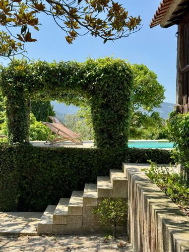 a set of stairs in a garden with an ivy frame at As Casinhas, Slow Living in Minho Quinta in Fontão