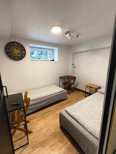 a room with two beds and a clock on the wall at Apartment typu suite LE BLEU in Płock