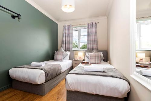 two beds in a room with two windows at Bridges Retreat, Newcastle in Gateshead