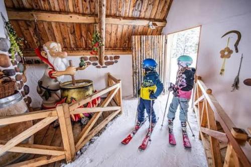 two children on skis in a room in a cabin at Hirzhof SO Bike&Ski Ridehaus Ski In Ski Out in Auberg