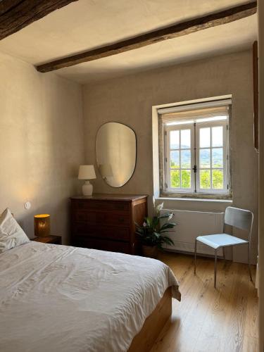 a bedroom with a bed and a mirror and a window at As Casinhas, Slow Living in Minho Quinta in Fontão