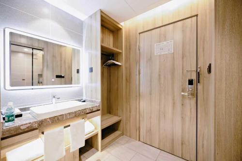 a bathroom with a sink and a mirror at Qingdao Likelai Garden Hotel in Qingdao