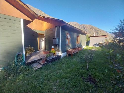 a small house with a porch and a yard at Refugio de montaña in El Manzano