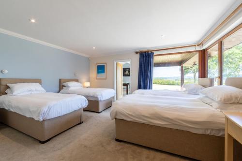 a bedroom with two beds and a window at Lakeside in Compton Martin