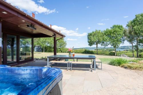 a patio with a table and a swimming pool at Lakeside in Compton Martin