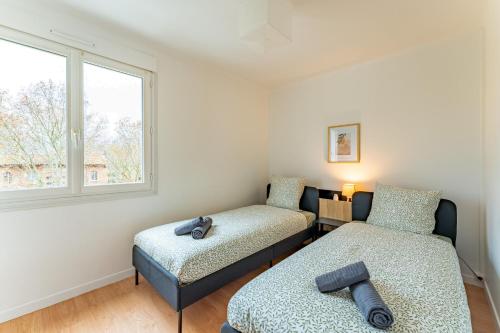 a bedroom with two beds and a window at Le bel Albi T3 tout équipé & wifi haut débit in La Celle-sous-Gouzon