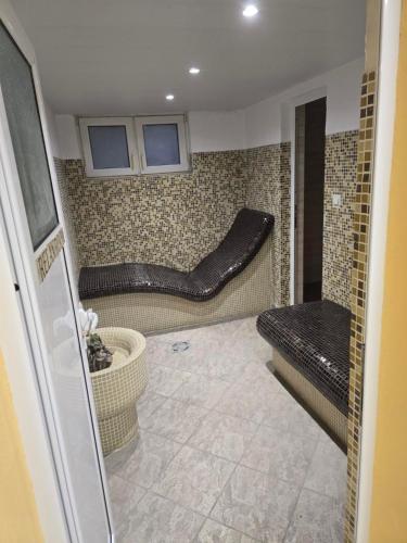 ein kleines Badezimmer mit einer Bank und einem Waschbecken in der Unterkunft Lovely 2-bedroom serviced apartment with SPA in Bansko