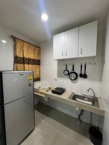 a small kitchen with a sink and a refrigerator at PMS Guest House Patong in Patong Beach