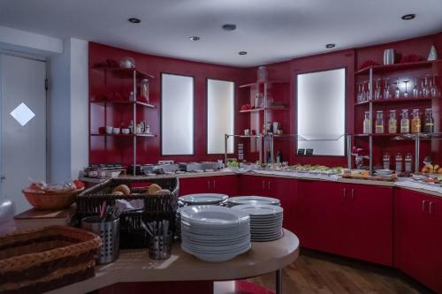 a kitchen with red cabinets and plates on a table at Stadt-gut-Hotel Rheinischer Hof in Essen
