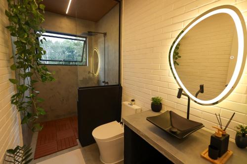 a bathroom with a mirror and a toilet and a sink at Casa de Campo - Valle Paixão in Campo Largo