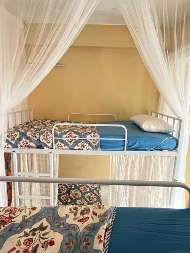 Dos literas en una habitación con cortinas en The Peach Villa, en Bombay