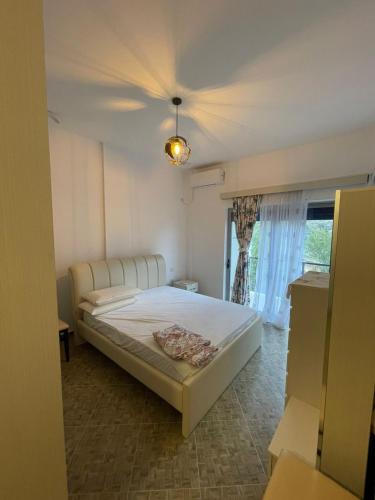 a bedroom with a white bed and a window at Villa Hoxha Tepelen in Tepelenë