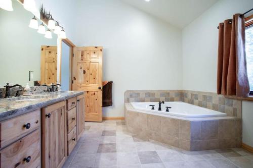 a large bathroom with a tub and a sink at Spacious Pet-Friendly Grand Lake House in Grand Lake