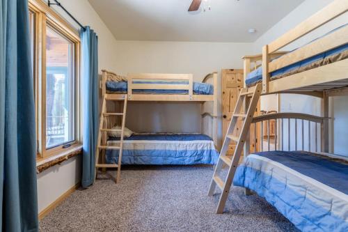 a bedroom with two bunk beds and a window at Spacious Pet-Friendly Grand Lake House in Grand Lake