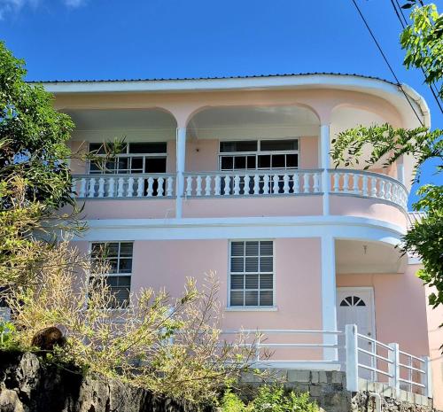 a pink house with a balcony on top of it at Ocean Sea view in Galion