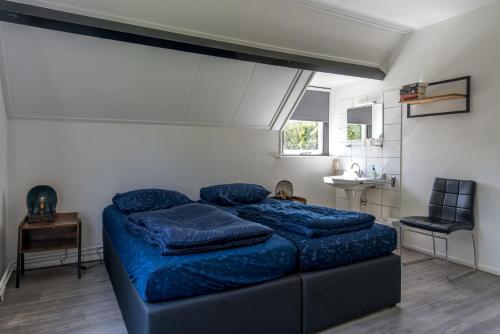 a bedroom with a bed with blue pillows on it at Noorderburcht in Oosterend