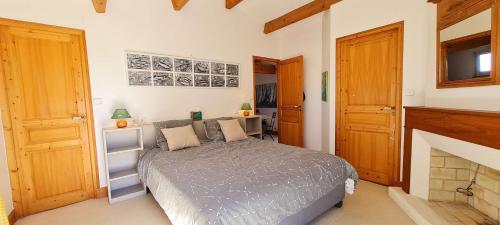 een slaapkamer met een bed en een open haard bij Dans le centre de la Couarde, superbe villa familiale in La Couarde-sur-Mer