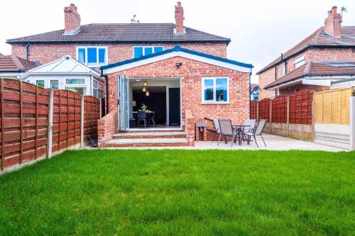 3 Bedroom Free Parking Hale Home في هييل: منزل من الطوب مع سياج وفناء