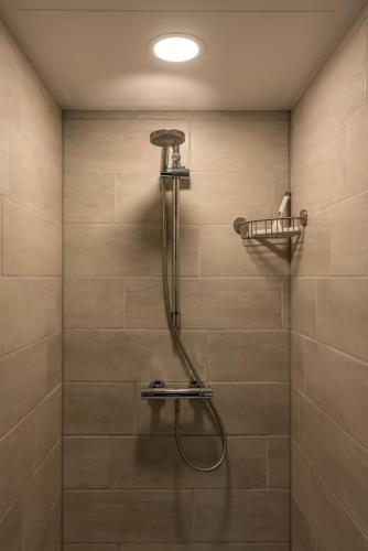 a shower with a shower head in a bathroom at Noorderburcht in Oosterend