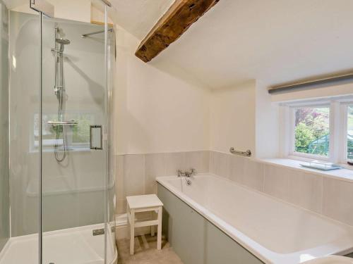 um banheiro com banheira e box de vidro em 4 Bed in Eskdale SZ158 em Eskdale
