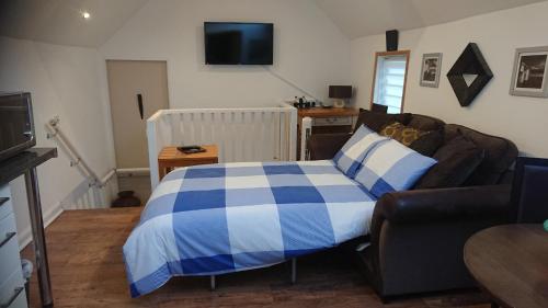 a bedroom with a blue and white bed and a couch at BexLet in Bexhill