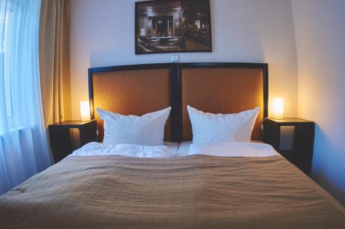 sypialnia z dużym łóżkiem z białą pościelą i poduszkami w obiekcie Apartment am Roten Stein w mieście Erfurt