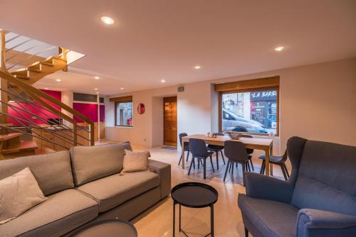 ein Wohnzimmer mit einer Couch und einem Tisch mit Stühlen in der Unterkunft Sejour prestige a Lannion entre ville et plages in Lannion