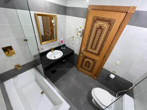 un bagno con un water, un lavandino e uno specchio di فندق رهف مكة Rahaf Hotel Maka a Al Khansāk