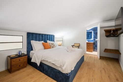 a bedroom with a large bed with a blue headboard at Duplex Suite Old Town in Antibes
