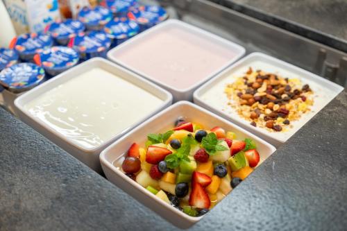Dos recipientes de plástico llenos de frutas y frutos secos sobre un mostrador. en Landhotel Untermüllnergut, en Dorfgastein