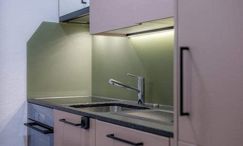 a kitchen with a sink and a mirror at Figaro in Leukerbad