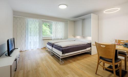 a bedroom with a bed and a desk at Figaro in Leukerbad