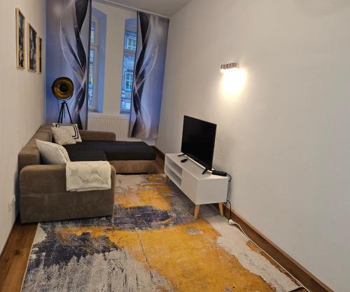 a living room with a couch and a tv at Olymp in Bamberg